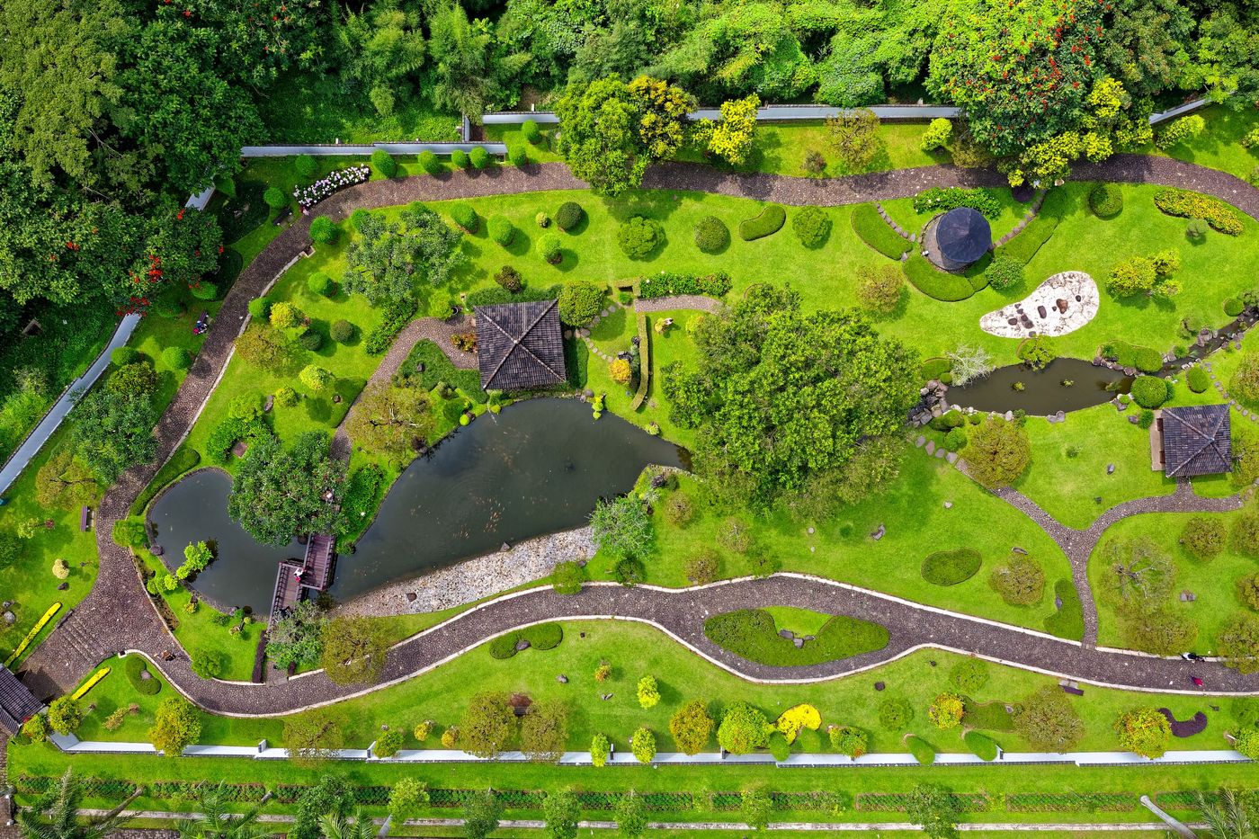 Parque urbano con arbolado, praderas y láminas de agua